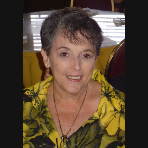 A close-up photo of Mary Lee Culotta smiling with a yellow floral shirt
