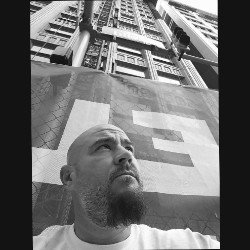 A black and white photo of Jason "JJ" Link pondering and looking upward