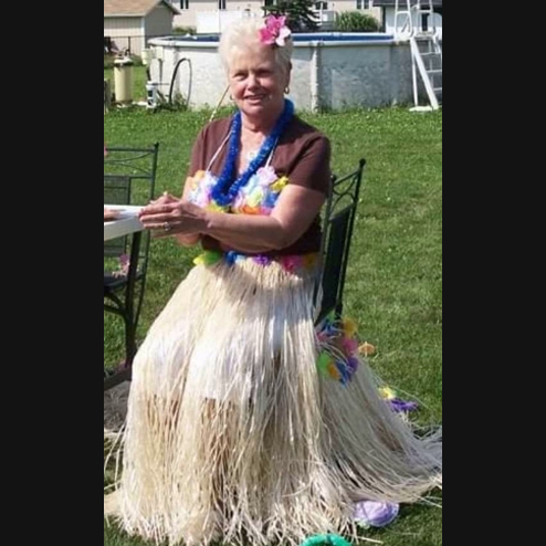 Dora "Faye" Freeman posing while in a hula outfit for a photo at a family celebration