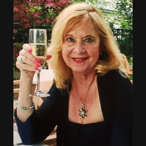 A photo of Gloria Jean Marcum posing with a glass of champagne