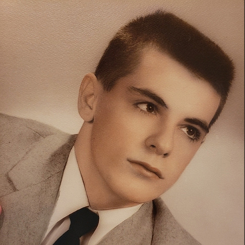 A sepia tone portrait photo of a young Paul Cudnik Sr. gazing into the distance