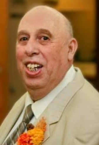 A close-up photo of Raymond "Ed" Serfass smiling at a formal event